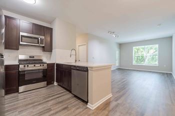 A kitchen with dark brown cabinets and stainless steel appliances.at Riverview Landing @ Valley Forge, Pennsylvania, 19403
